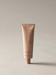 Tube of Magnolia & Sandalwood hand cream on a beige background