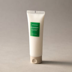 Tube of Aromatica Rosemary hair thickening conditioner on a gray background