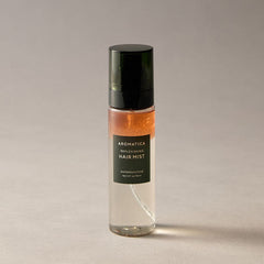 Aromatica replenishing hair mist bottle on a neutral background