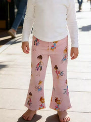 Child wearing pink bell-bottom pants with fairy print on a wooden floor.