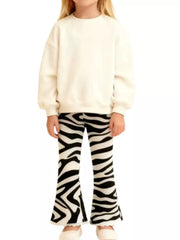 Child wearing a cream sweatshirt and zebra-striped pants on a white background