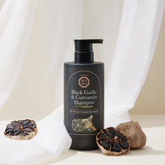Black Garlic & Curcumin Shampoo bottle with garlic bulbs on a white background