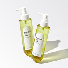 Two bottles of 'Better Root Hair Tonic' on a light background