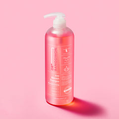 Pink shampoo bottle with pump on a pink background