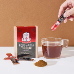 Red packet of Korean ginseng powder with a cup of tea and packaging on a brown background