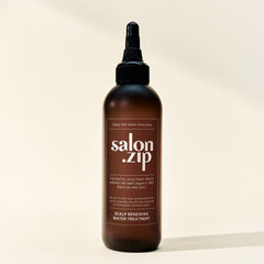 Bottle of 'salon.zip' scalp renewing water treatment on a beige background