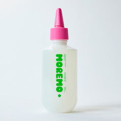 White bottle with pink cap and green text on a white background