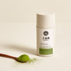 Ossulloc green tea powder with a spoonful of powder on a beige background