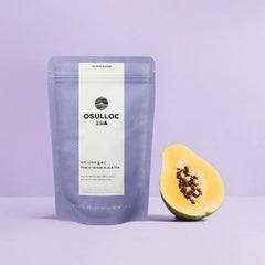 Osulloc tea package with a half-cut papaya on a light purple background