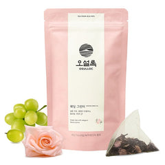 Osulloc tea package with green grapes, a pink rose, and a triangular tea bag on a white background