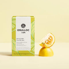 OSULLOC tea box with a sliced lemon on a light yellow background