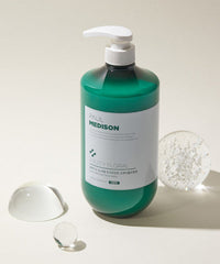 Green bottle with pump labeled 'Paul Medison' on a light background