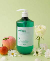 Green bottle of Paul Medison product with apples and flowers on a green background